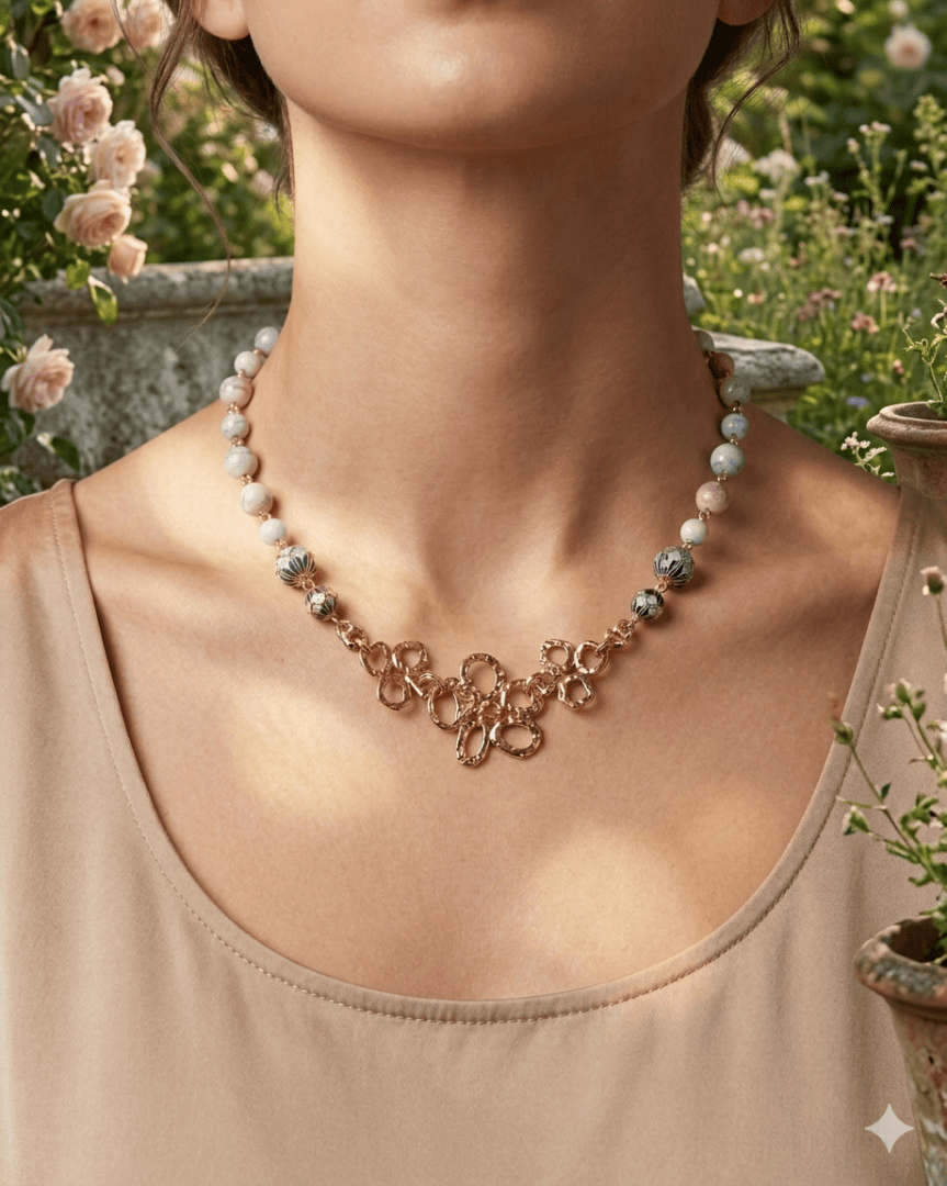 Handmade rainbow Alashan agate necklace with blue cloisonné beads, gold floral centerpiece, and hammered gold hook clasp inspired by Monet's gardens.