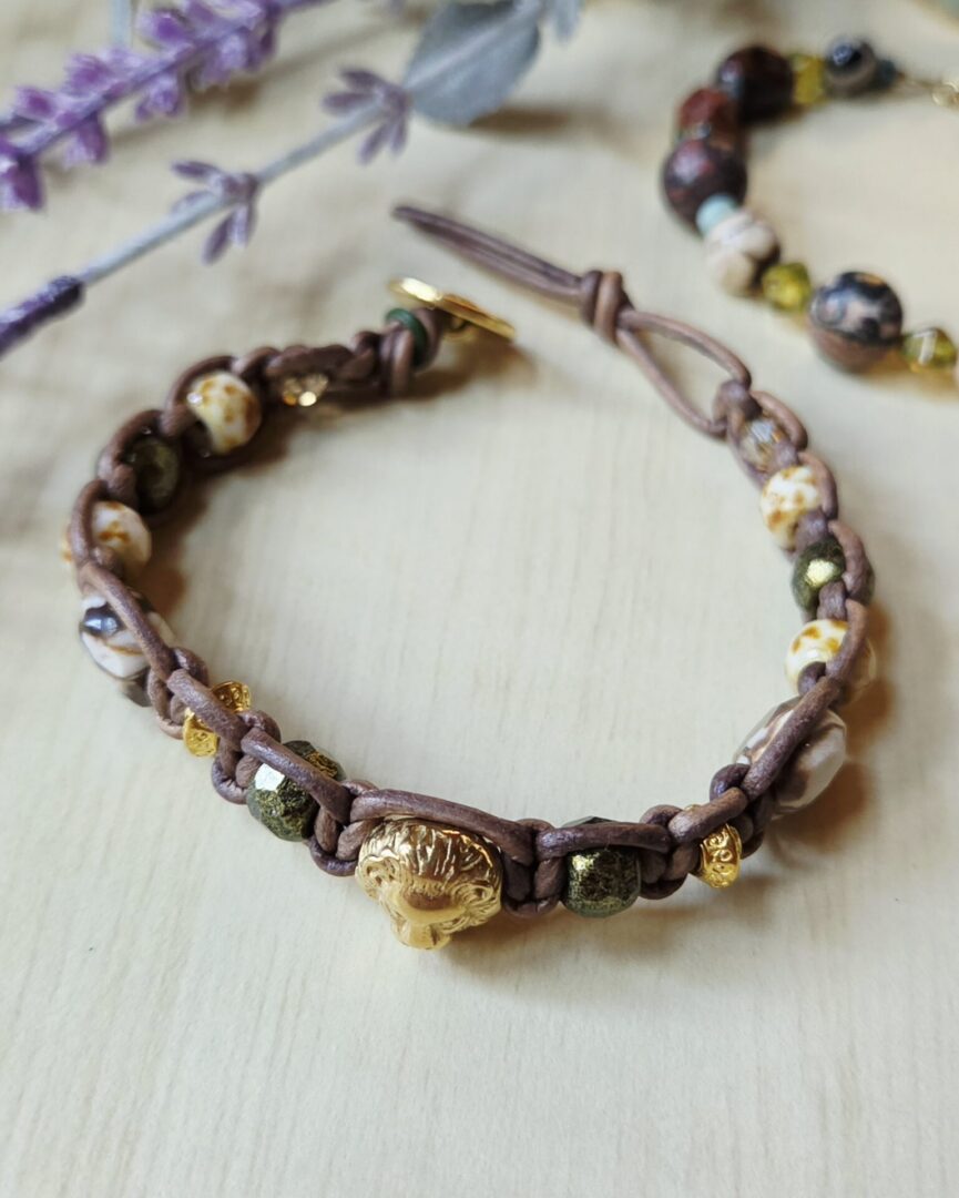 Brown leather bracelet with zebra jasper, gold and olive Czech glass beads, and lion focal.