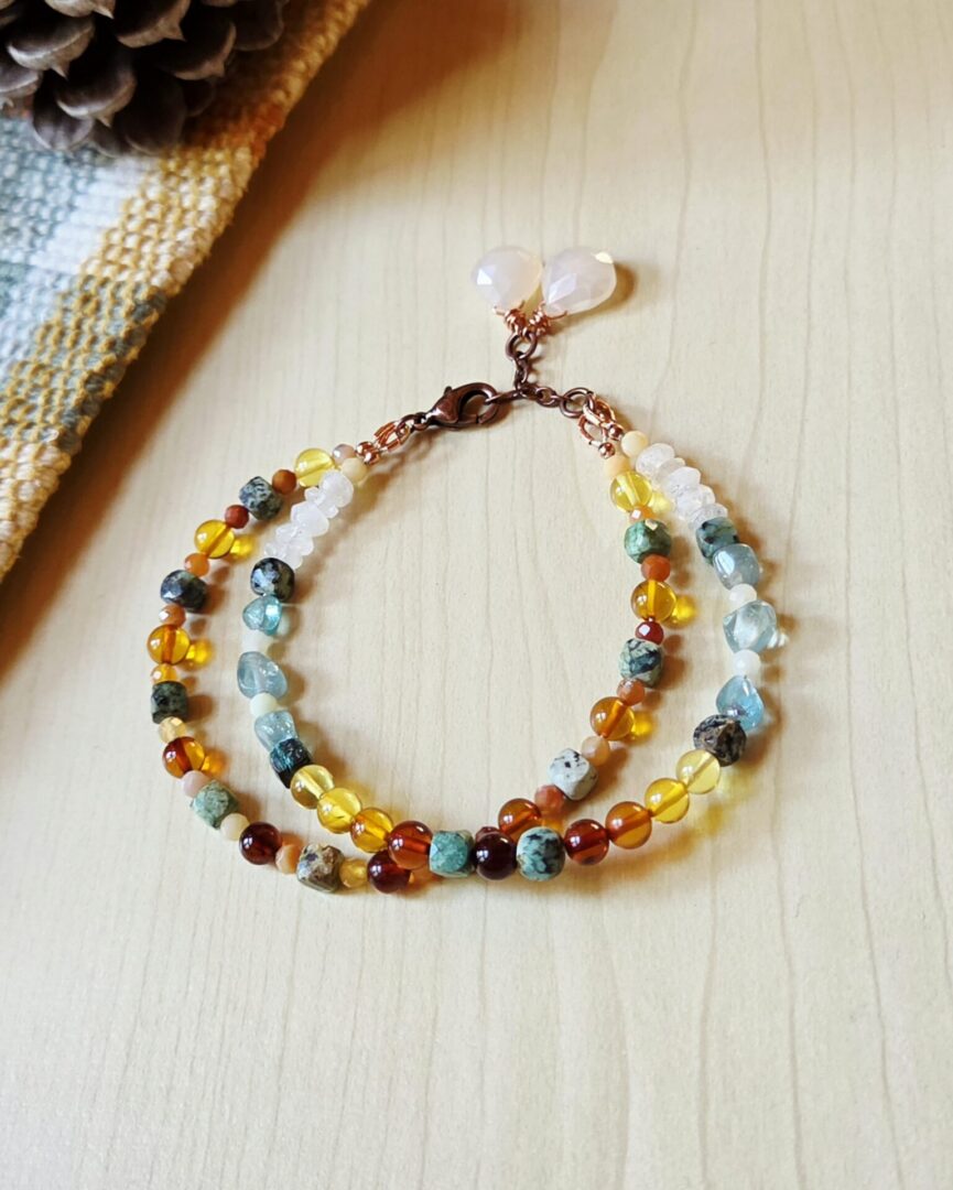 Handmade Harvest Pear gemstone bracelet with golden ombré fire opal and amber beads, blue-green African turquoise, pale moonstone and apatite, copper accents, and moonstone teardrop charms.